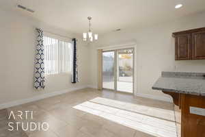 Unfurnished dining area featuring light tile patterned floors and an inviting chandelier