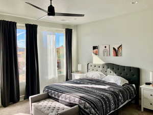 Bedroom with light carpet, a textured ceiling, and ceiling fan