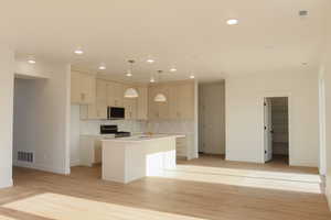 Kitchen featuring pendant lighting, backsplash, sink, an island with sink, and stainless steel appliances