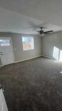 Interior space featuring a textured ceiling, carpet floors, and ceiling fan