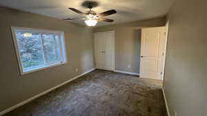 Unfurnished bedroom featuring carpet flooring and ceiling fan