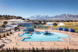 View of pool featuring a mountain view, a patio, and a water slide