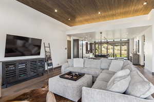 Living room featuring dark hardwood / wood-style floors, an inviting chandelier, and wood ceiling