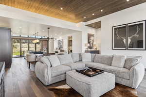 Living room with dark hardwood / wood-style flooring and wood ceiling