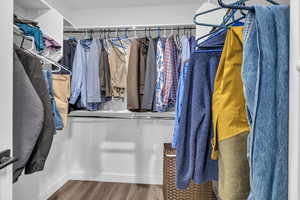 Spacious walk in closet featuring wood-type flooring