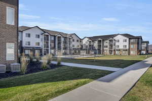 View of community featuring a lawn and pickleball court