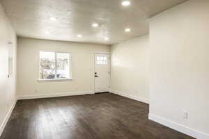 Foyer featuring dark hardwood / wood-style flooring and a textured ceiling