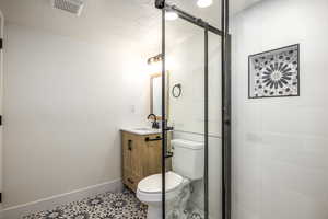 Bathroom with a textured ceiling, vanity, and toilet