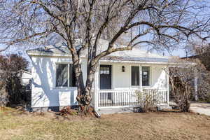 Bungalow-style house featuring covered porch and a front yard