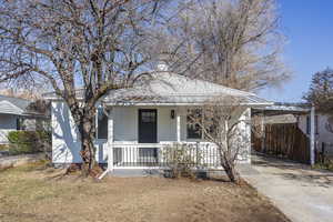 Bungalow-style home featuring a porch and a carport