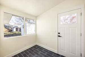 Entrance foyer featuring a healthy amount of sunlight and vaulted ceiling