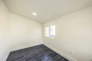 Unfurnished room featuring vaulted ceiling