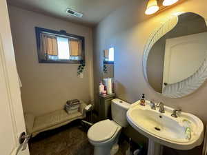 Bathroom featuring tile patterned flooring, toilet, and sink