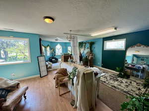 Living room with light hardwood / wood-style flooring, a chandelier, and a textured ceiling