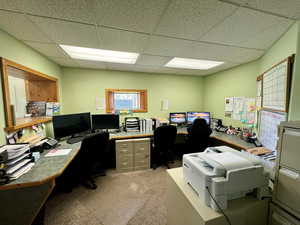 Carpeted office space with a paneled ceiling