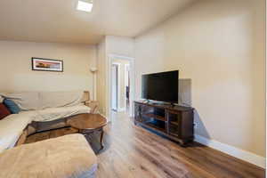 Living room featuring wood-type flooring and vaulted ceiling