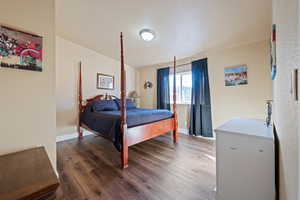 Bedroom featuring dark hardwood / wood-style flooring and a textured ceiling