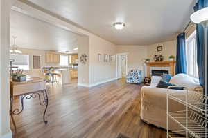 Living room featuring hardwood / wood-style floors, a textured ceiling, a tile fireplace, and a chandelier