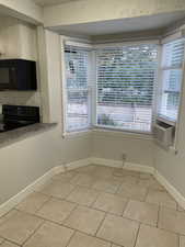 Unfurnished dining area featuring cooling unit and light tile patterned floors