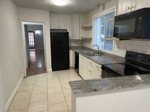 Kitchen with black appliances, decorative backsplash, a healthy amount of sunlight, and sink