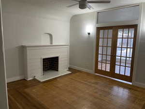 Unfurnished living room with french doors, a textured ceiling, dark hardwood / wood-style floors, and ceiling fan