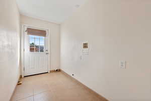 Laundry room featuring electric dryer hookup, light tile patterned floors, and washer hookup