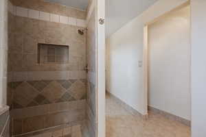 Bathroom with a tile shower and tile patterned floors