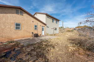 Back of house with central air condition unit and a patio area