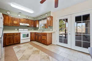 Kitchen featuring light tile patterned flooring, white appliances, sink, and french doors