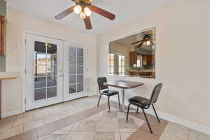 Tiled dining area featuring french doors and ceiling fan