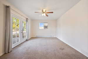 Carpeted empty room with baseboard heating, ceiling fan, french doors, and a wall unit AC