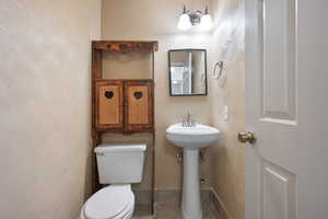 Bathroom with tile patterned floors, toilet, and sink