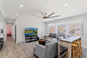 Living room with ceiling fan and hardwood style tile flooring