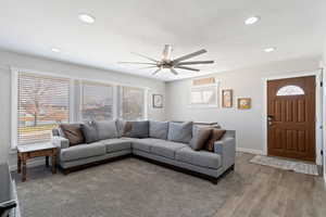 Living room featuring hardwood style tile floors and ceiling fan