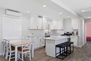 Kitchen featuring hardwood style tile flooring, white cabinets, and a kitchen island