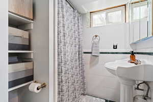 Bathroom featuring tile walls