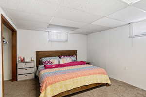 Carpeted bedroom featuring a drop ceiling