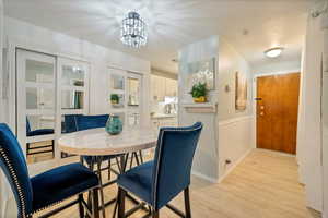 Dining area featuring sink, light hardwood / wood-style floors, and a notable chandelier