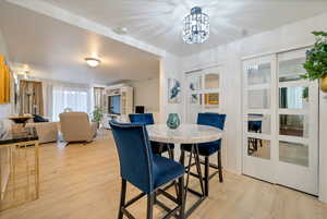 Dining space with light wood-type flooring and a notable chandelier