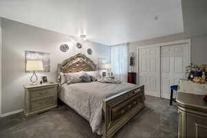 Bedroom with dark carpet and a closet