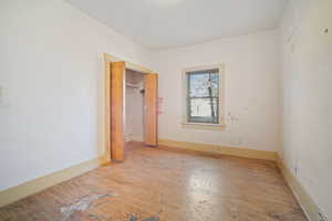 Unfurnished bedroom featuring a closet and light wood-type flooring