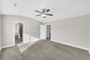 Unfurnished bedroom featuring ceiling fan, carpet, and vaulted ceiling