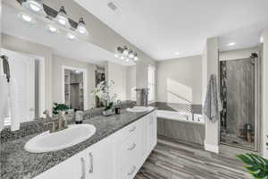 Bathroom featuring hardwood / wood-style floors, vanity, and independent shower and bath