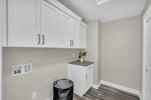 Clothes washing area with cabinets, washer hookup, and dark hardwood / wood-style floors