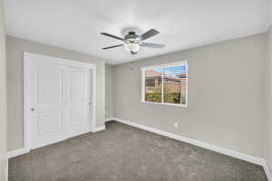 Unfurnished bedroom with carpet floors, a closet, and ceiling fan