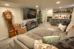 Carpeted living room with a textured ceiling, bar, and beverage cooler