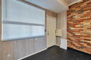 Entryway featuring wood walls and brick wall