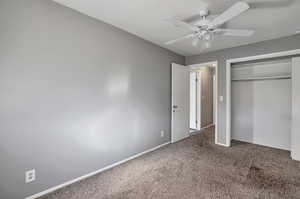 Unfurnished bedroom featuring ceiling fan, a closet, and carpet floors