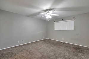 Carpeted empty room with ceiling fan