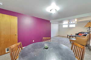 Dining space with a textured ceiling and light carpet